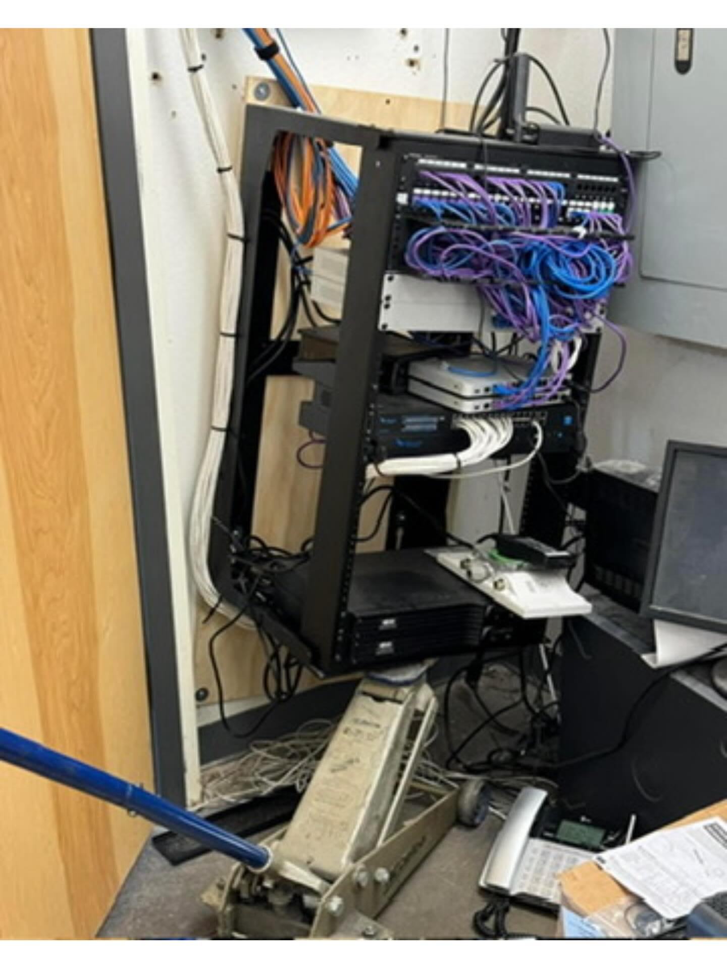 Before: disorganized network rack with tangled cabling in restaurant back office